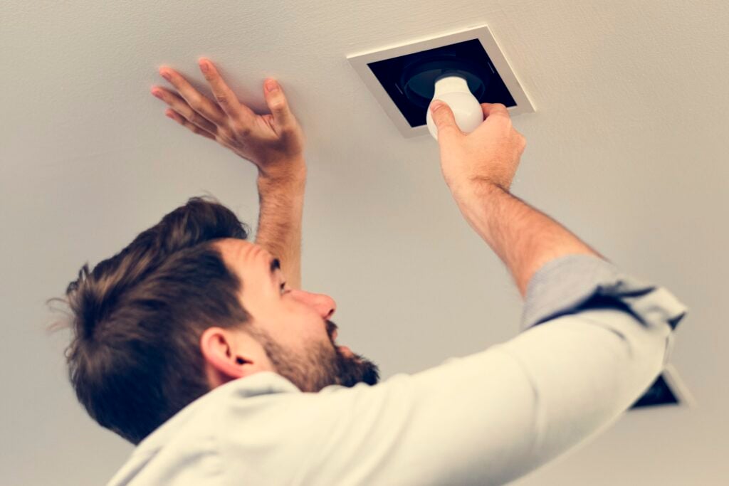 Changing exterior light bulbs to reduce flying insects near the home
