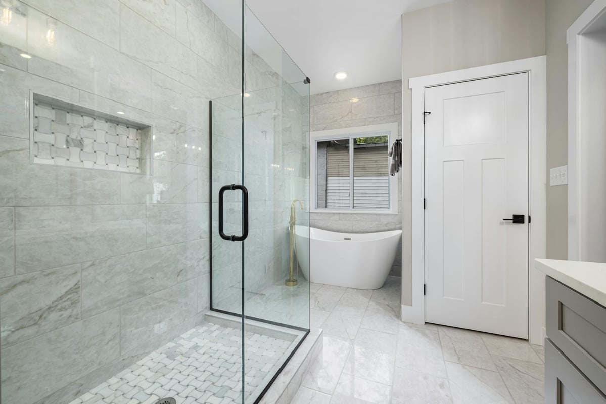 Bright modern bathroom featuring a glass shower and freestanding bathtub.